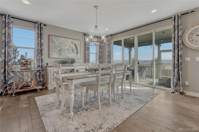 unfurnished dining area featuring hardwood / wood-style flooring and a notable chandelier