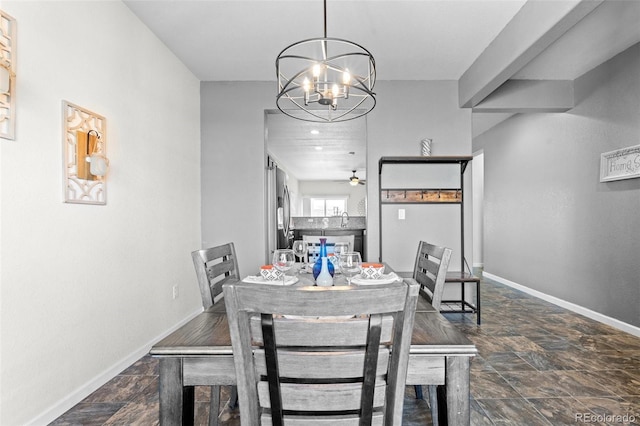 dining room featuring sink and ceiling fan with notable chandelier