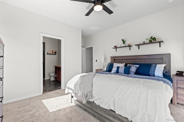 carpeted bedroom with ensuite bathroom and ceiling fan