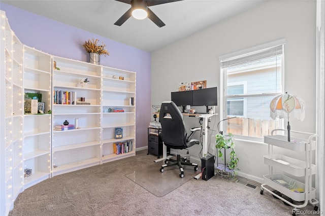 carpeted office space featuring ceiling fan