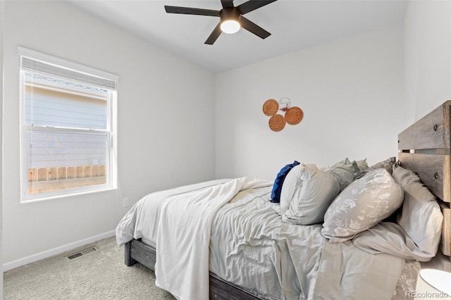 carpeted bedroom featuring ceiling fan and multiple windows