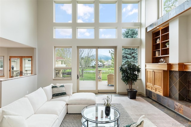 living room with a towering ceiling and a premium fireplace