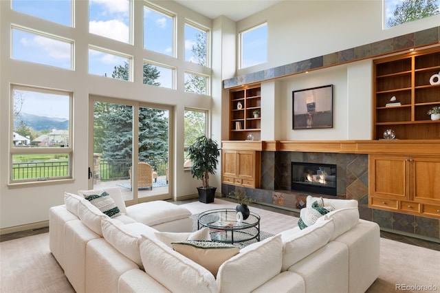 living room featuring built in shelves, a high end fireplace, and plenty of natural light