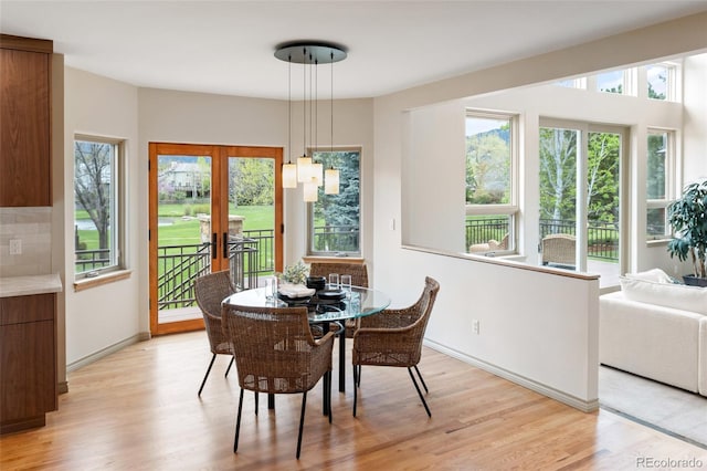 dining area with french doors and light hardwood / wood-style flooring