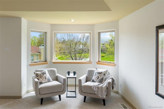 living area with a healthy amount of sunlight and light carpet