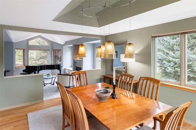 dining space with light hardwood / wood-style flooring and vaulted ceiling