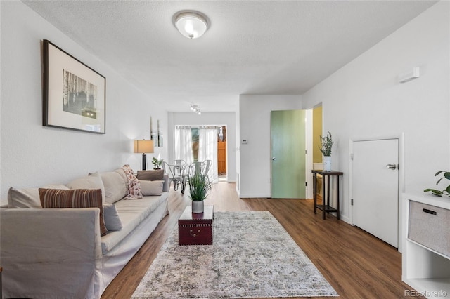 living area with a textured ceiling and wood finished floors