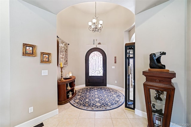 tiled entryway featuring an inviting chandelier