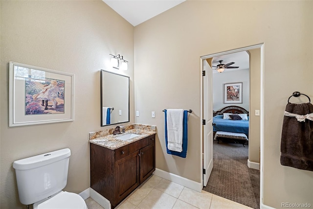 bathroom with toilet, ceiling fan, vanity with extensive cabinet space, and tile floors