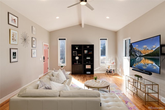 living area featuring vaulted ceiling with beams, a ceiling fan, baseboards, and wood finished floors