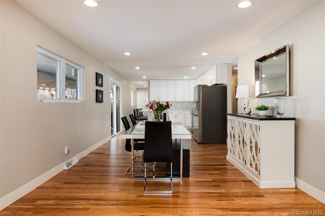 dining room with light wood-style flooring, recessed lighting, visible vents, and baseboards