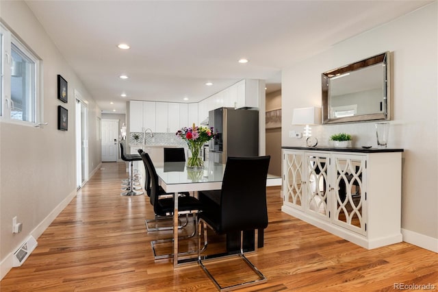 dining room with light wood-style floors, recessed lighting, visible vents, and baseboards