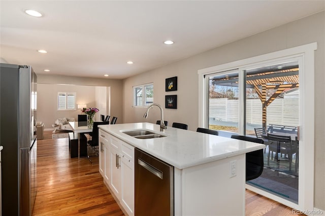 kitchen with recessed lighting, light wood-style flooring, appliances with stainless steel finishes, white cabinets, and a sink