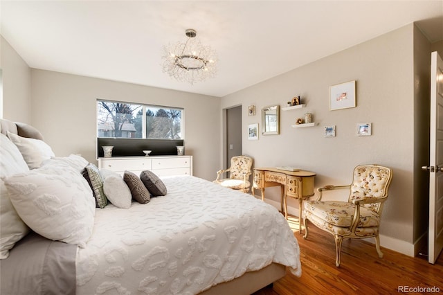 bedroom featuring a notable chandelier, baseboards, and wood finished floors