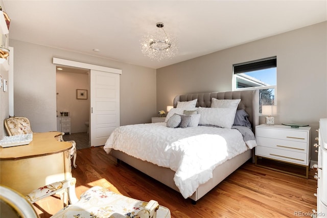 bedroom with light wood finished floors and an inviting chandelier