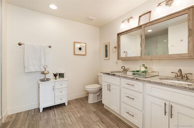 bathroom featuring double vanity, wood tiled floor, visible vents, and a sink