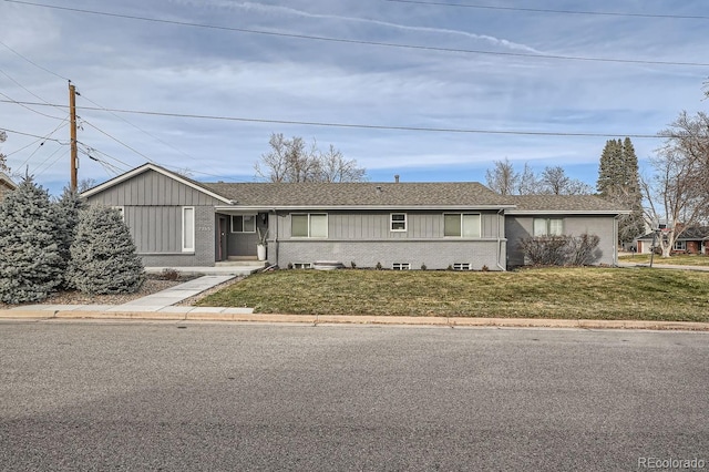 ranch-style home featuring brick siding, roof with shingles, and a front yard