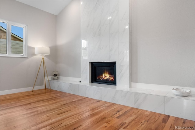 7155 E Exposition Ave, Denver, CO 80224 - unfurnished living room with a tiled fireplace and wood finished floors