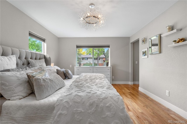 7155 E Exposition Ave, Denver, CO 80224 - bedroom featuring light wood finished floors and a chandelier