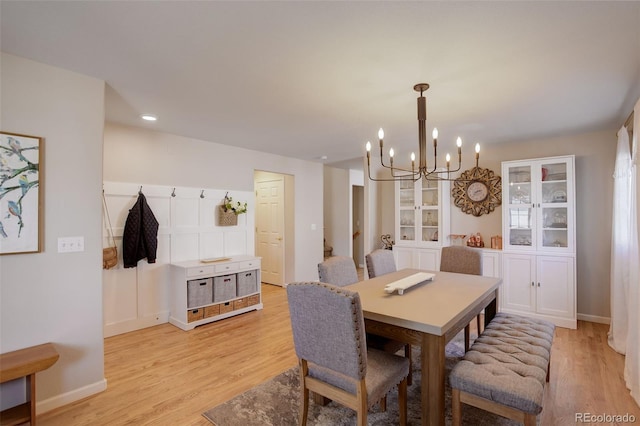 dining room with baseboards, light wood-type flooring, and a chandelier