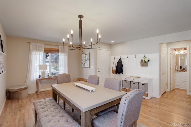 dining room with light wood-style flooring and an inviting chandelier