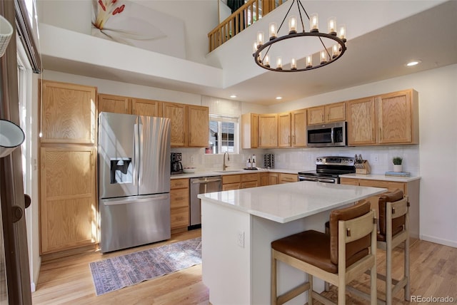 kitchen with stainless steel appliances, a sink, an inviting chandelier, and backsplash