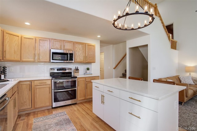 kitchen with tasteful backsplash, a notable chandelier, light brown cabinetry, and stainless steel appliances
