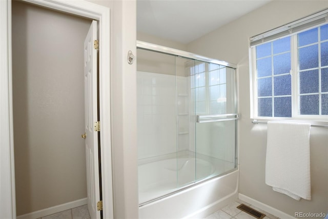 full bath featuring visible vents, baseboards, plenty of natural light, bath / shower combo with glass door, and tile patterned floors
