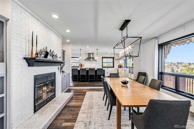 7388 S Ireland Cir, Centennial, CO 80016 - dining area featuring a fireplace, recessed lighting, dark wood-style floors, and a chandelier