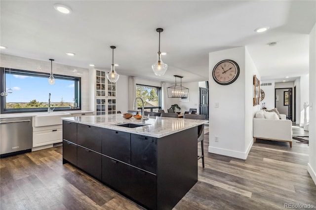 7388 S Ireland Cir, Centennial, CO 80016 - kitchen featuring stainless steel dishwasher, dark wood-style flooring, open floor plan, light stone countertops, and recessed lighting