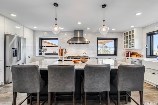 7388 S Ireland Cir, Centennial, CO 80016 - kitchen featuring wall chimney exhaust hood, stainless steel appliances, plenty of natural light, and recessed lighting
