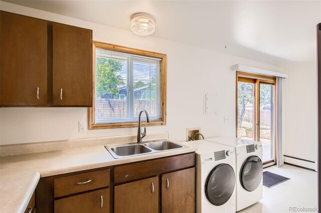 clothes washing area with cabinets, sink, a baseboard radiator, and independent washer and dryer