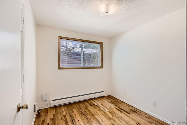 unfurnished room featuring light wood-type flooring, a textured ceiling, and a baseboard radiator