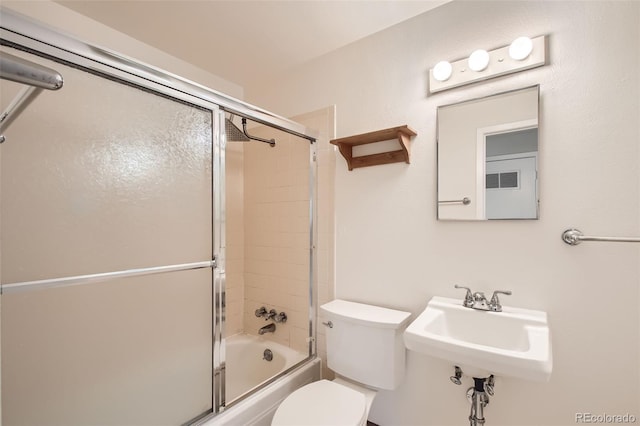 full bathroom with sink, toilet, and bath / shower combo with glass door