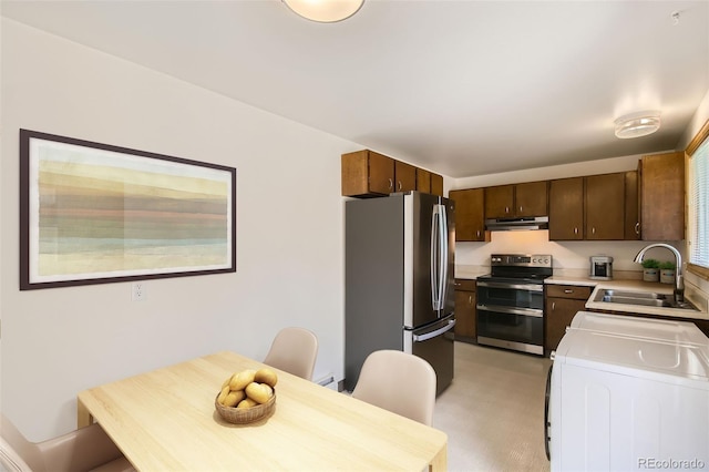 kitchen featuring independent washer and dryer, stainless steel appliances, and sink