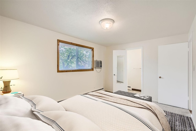 carpeted bedroom with a wall mounted AC, a textured ceiling, and a baseboard heating unit