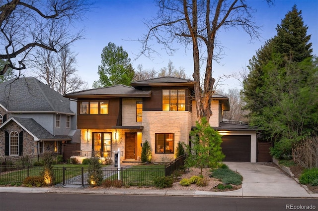 424 Grape St, Denver, CO 80220 - view of front of property featuring driveway, stone siding, a fenced front yard, and an attached garage