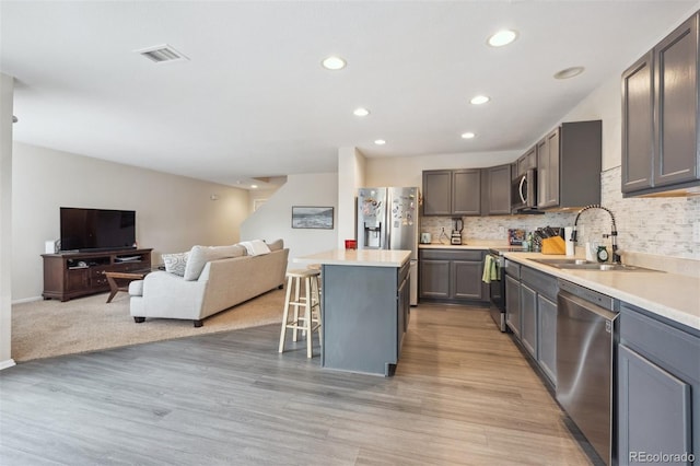 9316 Harrison St, Thornton, CO 80229 - kitchen with appliances with stainless steel finishes, a sink, open floor plan, a breakfast bar area, and a center island