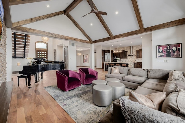 living area with beamed ceiling, high vaulted ceiling, visible vents, and light wood finished floors