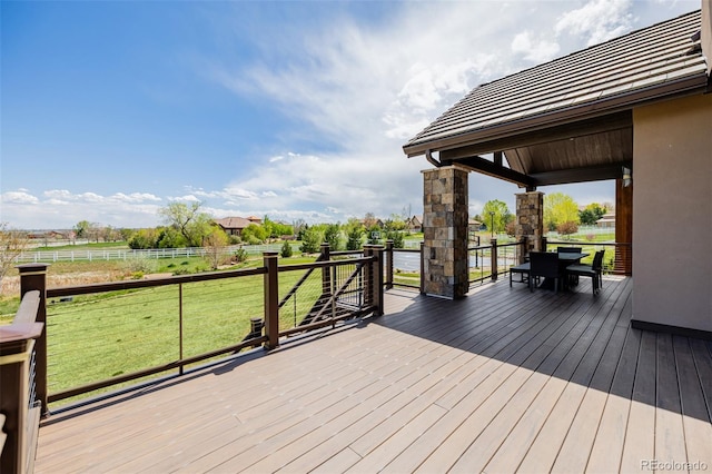 deck with a lawn, fence, and outdoor dining space