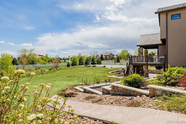 view of yard with fence, a garden, and stairs