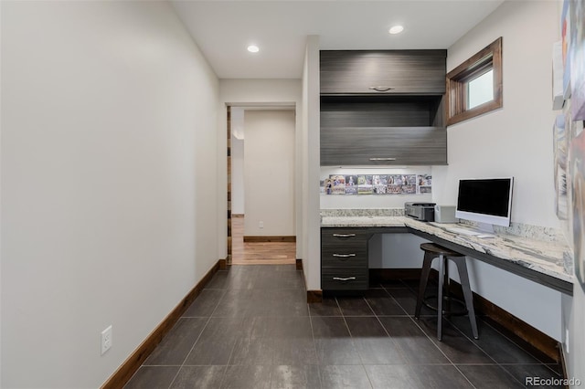 office area with built in study area, dark tile patterned floors, baseboards, and recessed lighting