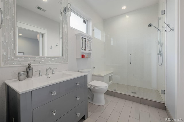 full bathroom featuring tile patterned flooring, vanity, toilet, visible vents, and a stall shower
