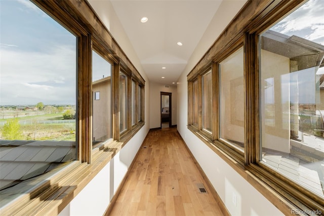 hallway featuring recessed lighting, vaulted ceiling, light wood finished floors, and visible vents