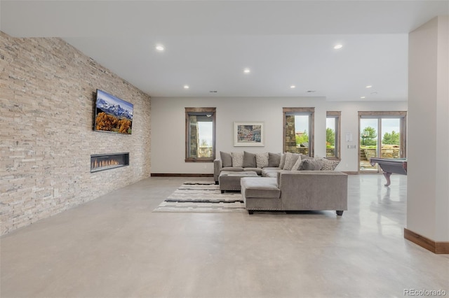 living room with recessed lighting, concrete flooring, pool table, and a fireplace
