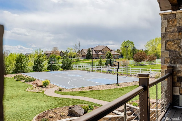 view of sport court featuring a lawn, community basketball court, and fence