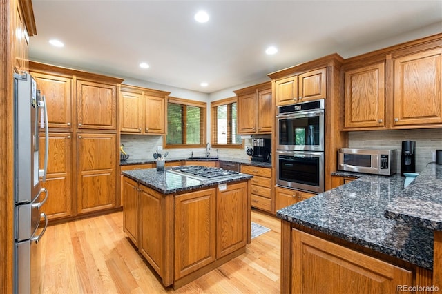 3935 Pierson St, Wheat Ridge, CO 80033 - kitchen with stainless steel appliances, light wood-type flooring, brown cabinetry, tasteful backsplash, and recessed lighting