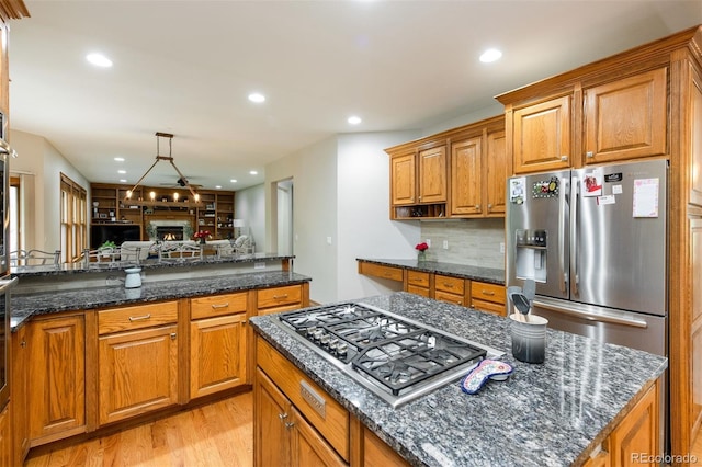 3935 Pierson St, Wheat Ridge, CO 80033 - kitchen with stainless steel appliances, brown cabinetry, light wood-style flooring, and recessed lighting