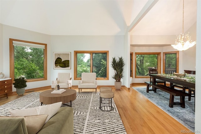 3935 Pierson St, Wheat Ridge, CO 80033 - living area featuring healthy amount of natural light, light wood-type flooring, a chandelier, and lofted ceiling