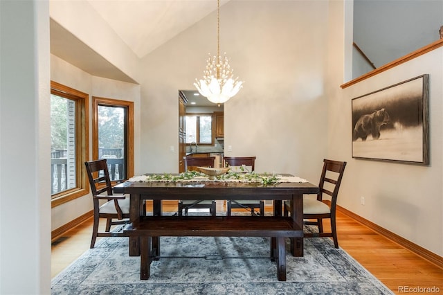 3935 Pierson St, Wheat Ridge, CO 80033 - dining area with a chandelier, light wood-style floors, and high vaulted ceiling
